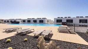 A rooftop pool area with lounge chairs and a modern building in the background. - Home2Book Modern Bright Apt Abades, Pool & Terrace (Abades)