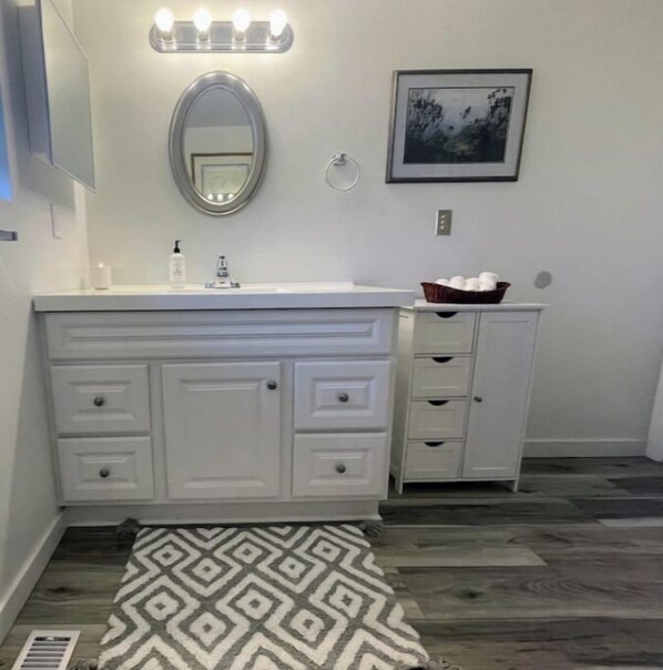 Un baño con tocador, espejo y lavabo.