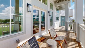 A covered porch with two wicker chairs, a small round table, and a welcome mat. - Foosball Table, Resort Pools, Golf Cart Boardwalk to the Beach, Pet Friendly (Port Aransas)