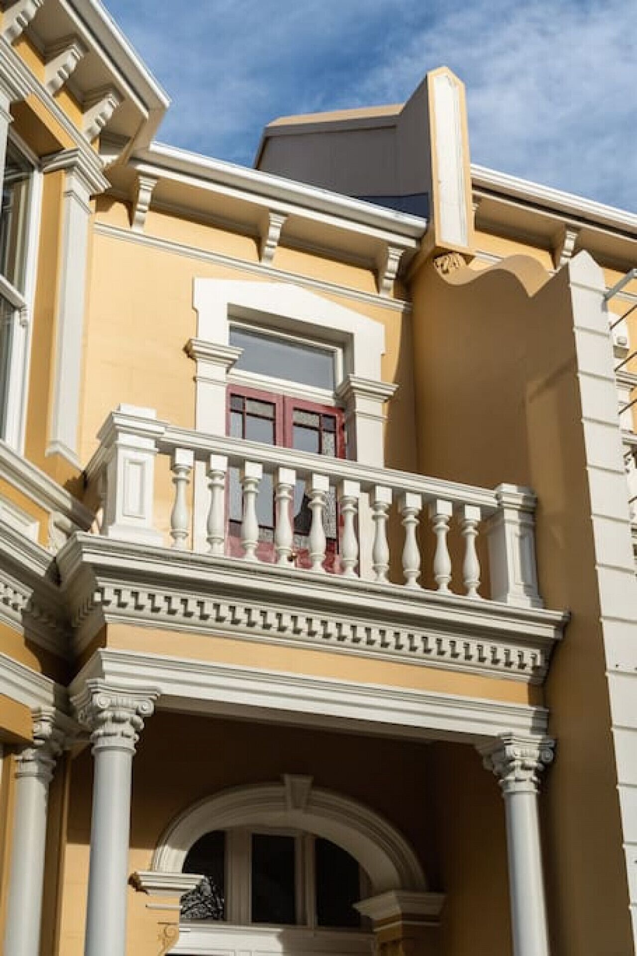A building with a balcony, columns, and a window.