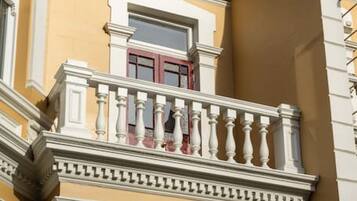 A building with a balcony, columns, and a window.
