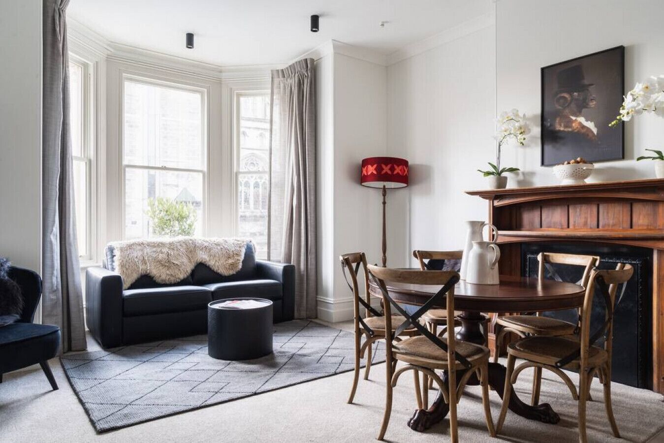 A living room with a dark sofa, wooden chairs, a coffee table, and a fireplace.