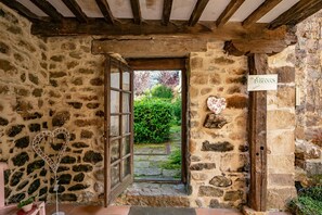 Une entrée en pierre, avec une porte en bois, un décor en forme de cœur et une enseigne indiquant « Casa de las Indianas ».