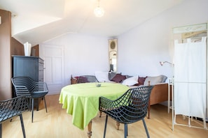 Et værelse med seng, et bord med stole, et klædeskab og et spejl.