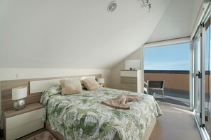 A bedroom with a bed, nightstands, a lamp, a chair, and a balcony with a view.