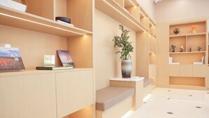 A modern interior with built-in shelving, a potted plant, and a clean, tiled floor. - Traffic Hotel (Dabu)