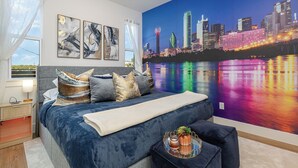 Een moderne slaapkamer met een groot bed, stadsgezicht muurschildering en kunst aan de wand.
