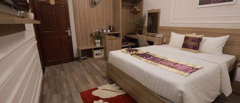 A bedroom with a bed, bedside table, wardrobe, desk, chair, and a mirror.
