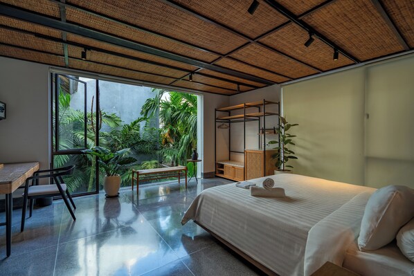Ein modernes Schlafzimmer mit einem großen Bett, einem Schreibtisch und einer Sitzecke.