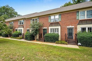 A row of brick townhouses with front porches, green shutters, and a well-maintained lawn. - Royal Tiger - Walk to Death Valley! (Clemson)
