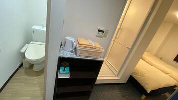 Een bad/douchecombinatie, een haardroger, pantoffels, een bidet