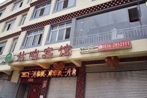 A building with a sign that reads 'Feng Xia Bing Hotel' and a phone number.