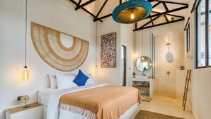 A modern bedroom with a bed, bedside table, and a large woven wall hanging. - Zig Zag Loft (Canggu)