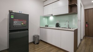 Eine kleine Küche mit Kühlschrank, Spüle und Holzschränken.