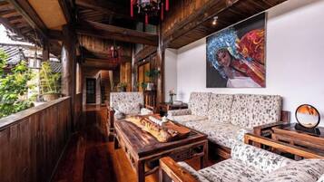 A traditional wooden interior with a sofa, a wooden table, and a hanging decoration.