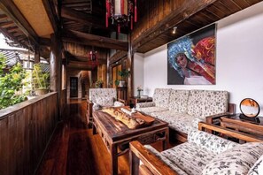 Interior em madeira com um sofá, uma mesa e um quadro.
