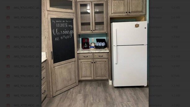 A kitchen with wooden cabinets, a white refrigerator, and a chalkboard with a motivational quote. - Peaceful Meadows - Peaceful Meadows (Flat Rock)