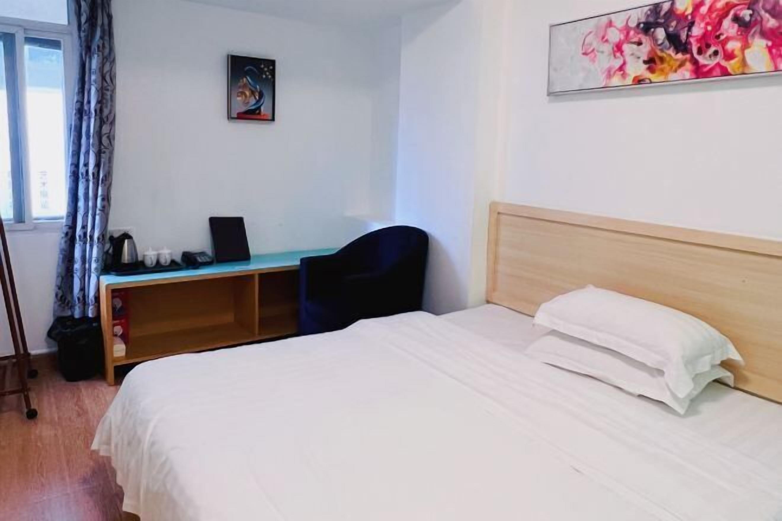 Une chambre d’hôtel avec un lit, un bureau et une chaise.