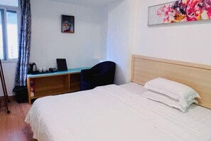 A hotel room with a bed, a desk, and a chair. - Guangdong Educational Activities Center (Guangzhou)