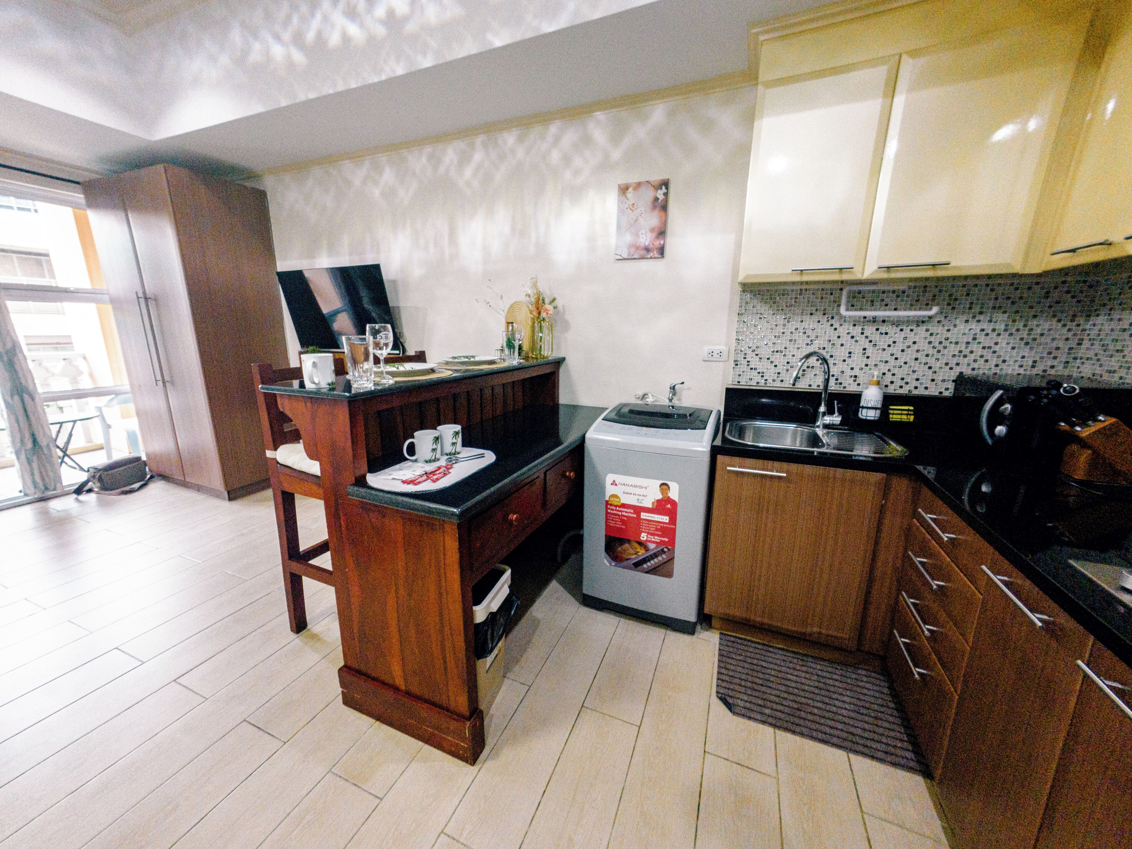 A compact kitchen with wooden cabinets, a built-in microwave, and a sink.