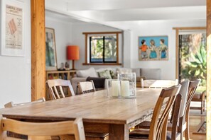 A dining area with a wooden table, chairs, and a glass candle holder.