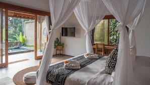 Une chambre à coucher avec un lit à baldaquin, donnant sur un jardin, et avec une piscine à l’extérieur.