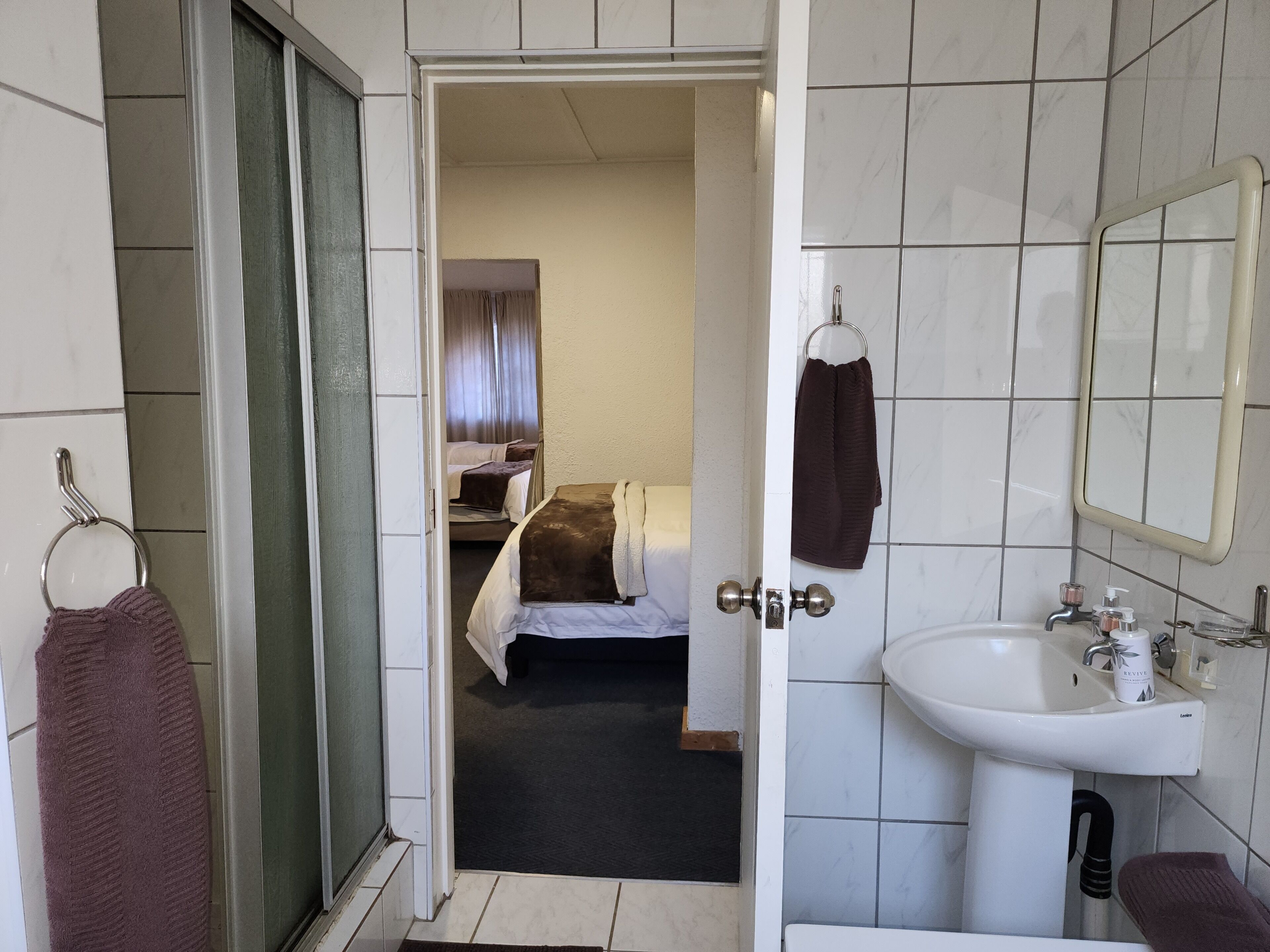 Ein Badezimmer in einem Hotel mit Waschbecken, Spiegel und Handtuchhalter.