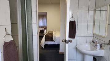 Ein Badezimmer in einem Hotel mit Waschbecken, Spiegel und Handtuchhalter.