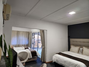 Una camera d'albergo con due letti, un'ampia finestra e vista sull'esterno.