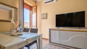 Ein Hotelzimmer mit Esstisch, Stühlen, einem Fernseher und einem Schrank.