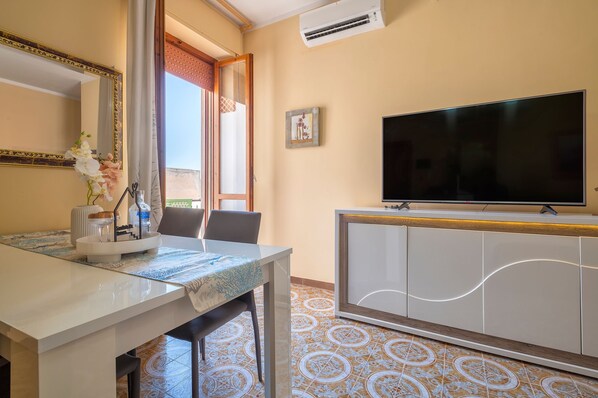 Une chambre d’hôtel équipée d’une table à manger, de chaises, d’un téléviseur et d’un meuble.