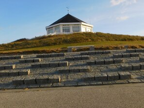 Un bâtiment blanc avec un toit noir, appelé « MARIEN HÖHE », situé sur une colline verdoyante, accessible par des marches en pierre.