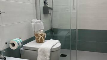 Un baño con inodoro, bidé y ducha.