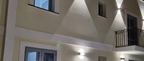 Un bâtiment à deux étages doté d’une façade symétrique, de nombreuses fenêtres et d’un balcon.