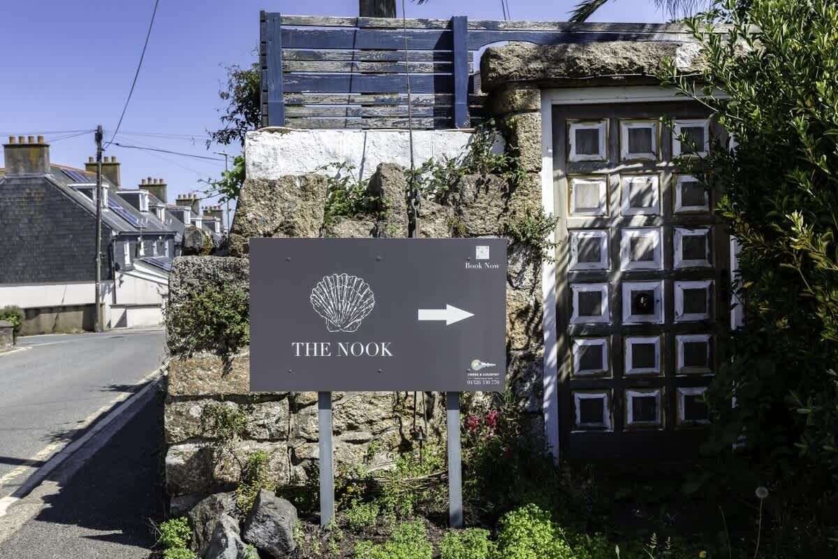 A sign for 'The Nook' with an arrow pointing to the right, indicating the direction to the establishment.
