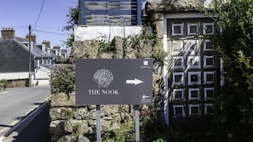 A sign for 'The Nook' with an arrow pointing to the right, indicating the direction to the establishment.