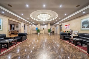 A hotel lobby with a marble floor, seating areas, a reception desk, and a chandelier. - Electric Machine Hotel (Yongji)