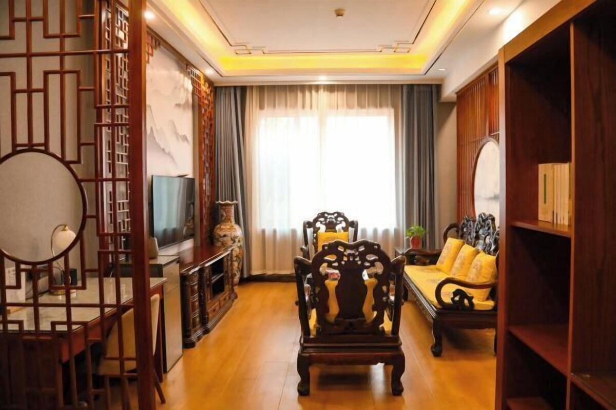 A traditional-style living room with a sofa, wooden furniture, and a TV.