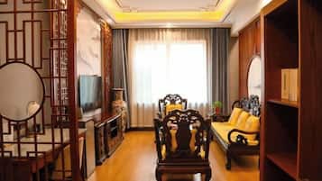 A traditional-style living room with a sofa, wooden furniture, and a TV.