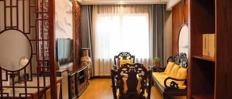 A traditional-style living room with a sofa, wooden furniture, and a TV.