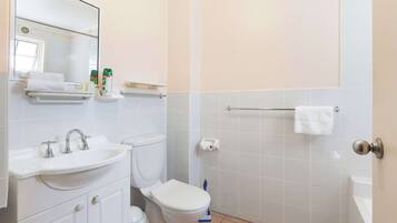 A bathroom with a sink, toilet, and shower area.