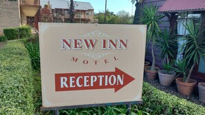 Schild des New Inn Motel, das den Bereich der Rezeption kennzeichnet.