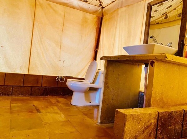 A small, enclosed bathroom with a toilet and a sink. - Sam Resort and Camp (Jaisalmer)