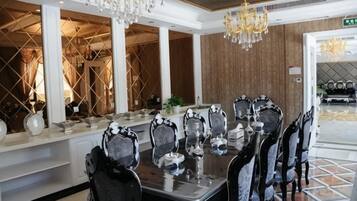 Un espace repas avec une longue table, des chaises et des lustres.