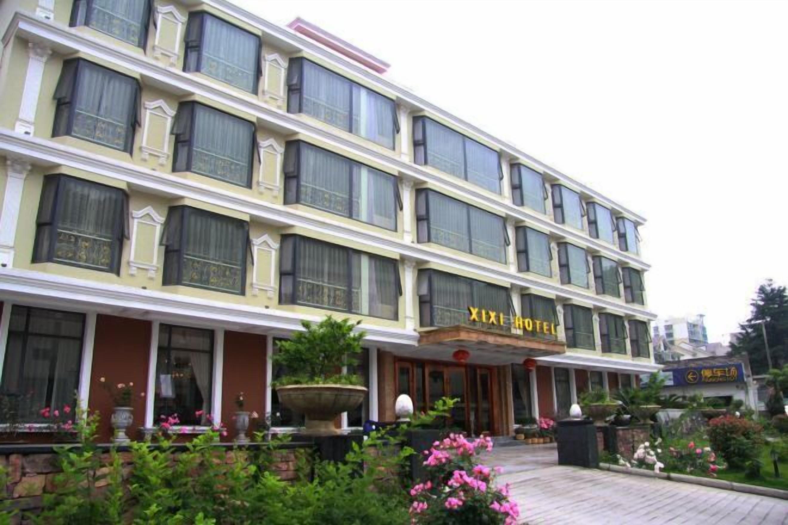 Um hotel com vários andares e estilo arquitetônico clássico, com grandes janelas e uma entrada imponente com um letreiro.
