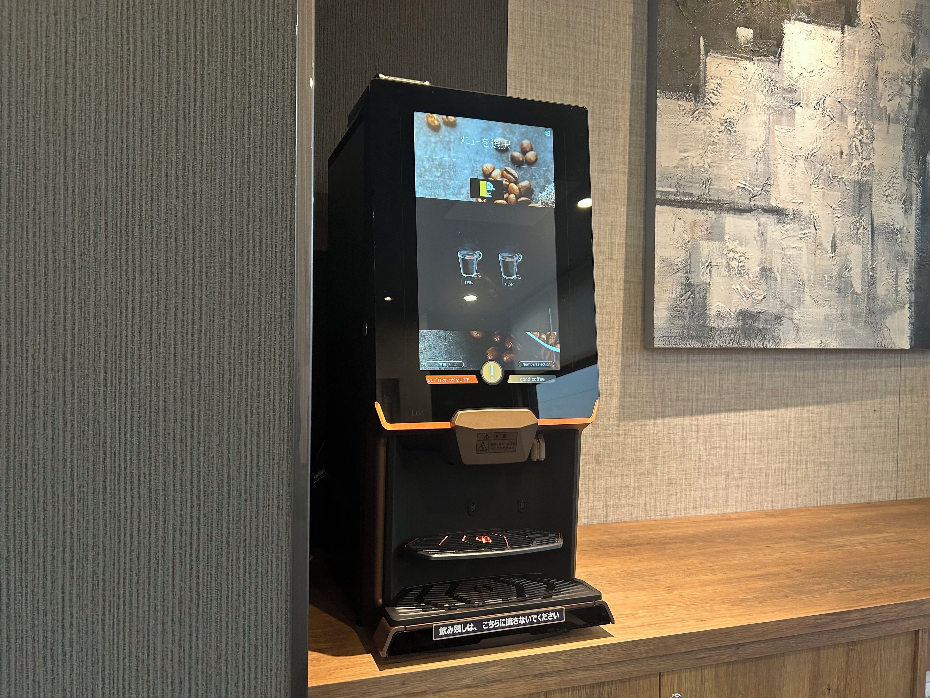 A coffee machine with a digital interface, a coffee cup, and a coffee pot.