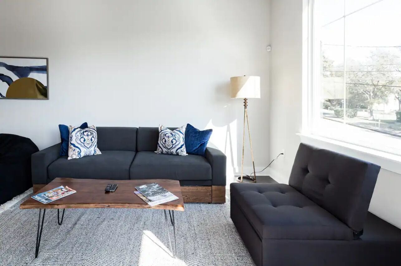 A modern living room with a grey sofa, a wooden coffee table, and a floor lamp.
