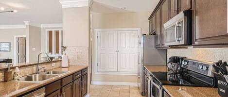 A modern kitchen with stainless steel appliances, a double sink, and a large island.