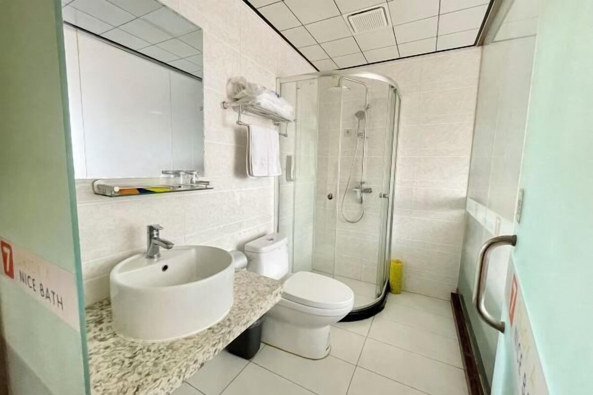 Un baño con lavamanos, inodoro y ducha con mampara de vidrio.