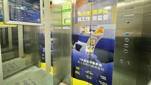 An elevator interior with a poster advertising a hotel service.